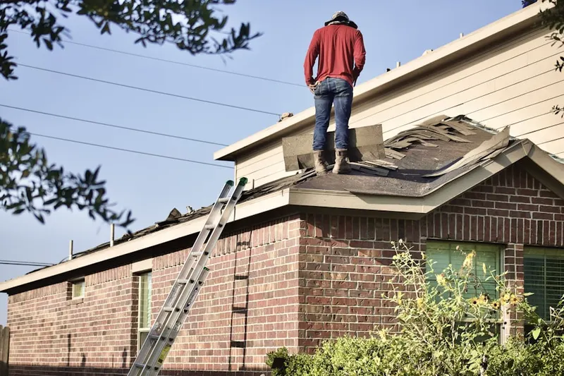 Professional roofer working on a residential roof in Le Mars